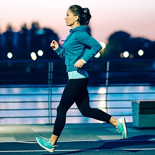 woman running sunset city outdoors | Holmes Place