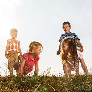 four kids barrel walking fun park exercise sunny day | Holmes Place
